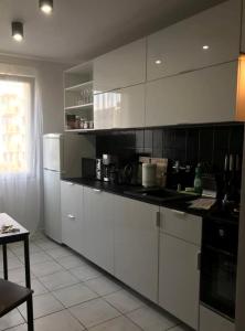 a kitchen with white cabinets and a black counter top at Mieszkanie Osiedle Slichowice, Targi Kielce 3,5km, faktury VAT in Kielce