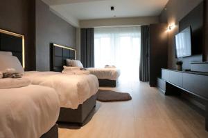 a hotel room with two beds and a television at Hotel54 Luxury Suite in Sakarya