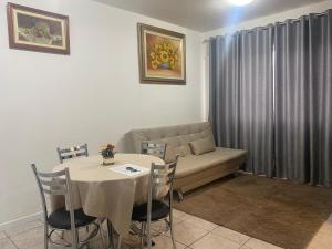 a living room with a table and a couch at Ap aconchegante no centro de Joinville com vaga in Joinville