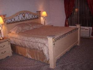 a large bed in a bedroom with two lamps at Chateau Royale Inn in Lake Geneva