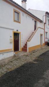 Casa blanca con escalera y puerta en Casa da Portagem by Portus Alacer en Marvão