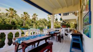 un patio con mesas, sillas y palmeras en Hosteria Mar y Sol en San Andrés