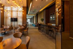 a bar in a restaurant with tables and chairs at Royal Palm Tower Anhanguera in Campinas