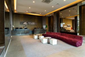 a lobby with a red couch and white tables at Royal Palm Tower Anhanguera in Campinas