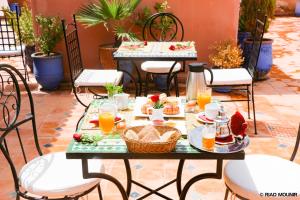 a table with food and drinks on a patio at Riad Mounir in Marrakesh