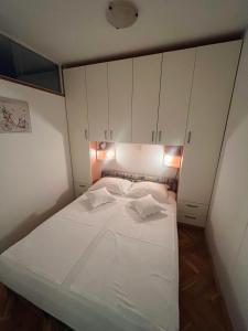 a small bed in a room with white cabinets at Apartment Trogir City in Trogir