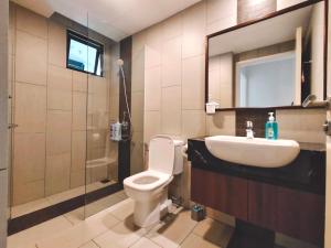 La salle de bains est pourvue de toilettes, d'un lavabo et d'un miroir. dans l'établissement THE LANDMARK BY KATANA New 3BR Grand Seaview Homestay at Gurney 无敌海景三房套房, à Tanjung Bungah
