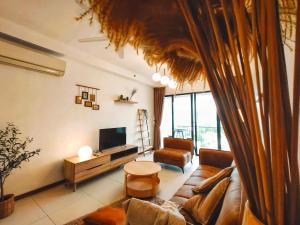 a living room with a couch and a tv at THE LANDMARK BY KATANA New 3BR Grand Seaview Homestay at Gurney 无敌海景三房套房 in Tanjung Bungah