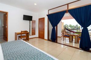Plaza Luna Suites في بويرتو أيورا: غرفة نوم بسرير والستائر الزرقاء وطاولة