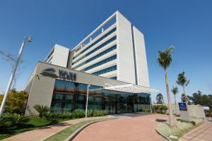 a tall white building with palm trees in front of it at Royal Palm Tower Anhanguera in Campinas