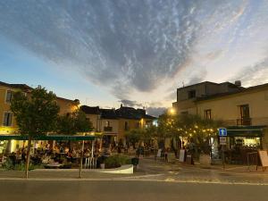 Un groupe de personnes assises à des tables dans une rue dans l'établissement Espace Le Cheval Blanc, à Castelnau-le-Lez