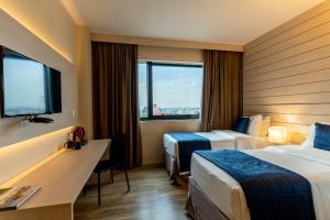 Una cama o camas en una habitación de Hotel Contemporâneo - Royal Palm Hotels & Resorts