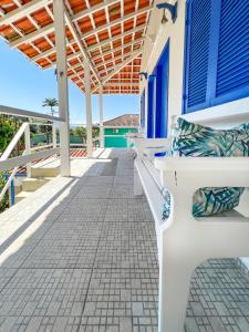 une terrasse couverte d'une maison avec des portes et des bancs bleus dans l'établissement Pousada Costa Verde, à Abraão