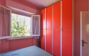 um quarto vermelho com uma cama e uma janela em Pet Friendly Apartment In Marcelli With Kitchen em Marcelli