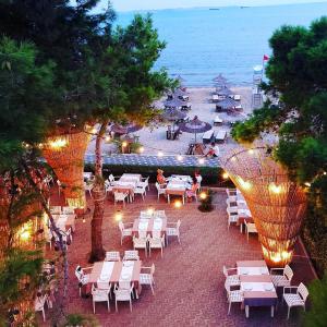 een uitzicht over het strand met tafels en stoelen bij COSMO Beach Hotel in Durrës