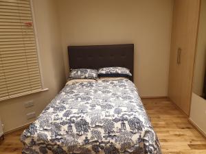 ein Schlafzimmer mit einem Bett mit einer Steppdecke darauf in der Unterkunft London Luxury Apartments 5 min walk from Ilford Station, with FREE PARKING & FREE WIFI in Ilford