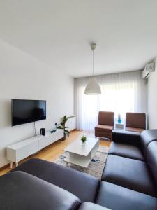 a living room with a couch and a tv at Sleep & Rest in Skopje