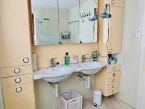 a bathroom with two sinks and a mirror at Ferien-Sempachersee Sandra Sens in Sempach