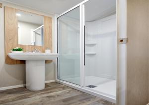 a bathroom with a glass shower and a sink at Caravan on Fantastic site in Dunbar