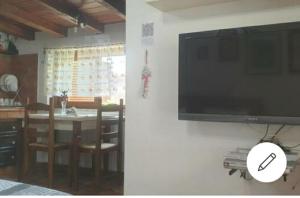 TV colgada en la pared de la sala de estar en Suite Felix en Fiumicino