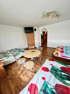 a room with two beds and a table and chairs at Pensjonat Sabina in Koszarawa