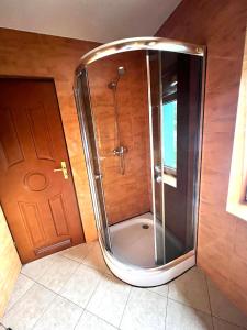 a shower with a glass door in a bathroom at Pensjonat Sabina in Koszarawa
