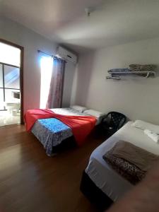 een kleine kamer met 2 bedden en een raam bij D'Casa Hotel e restaurante in Marechal Cândido Rondon