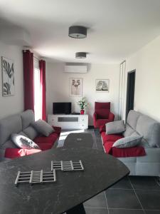 salon z kanapą i czerwonymi krzesłami w obiekcie Maison 8 personnes Biscarrosse bourg w mieście Biscarrosse