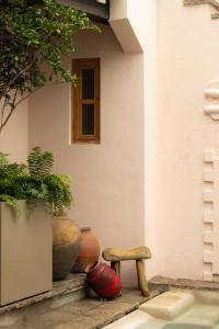 a corner of a house with vases and a stool at La Valise San Miguel de Allende in San Miguel de Allende