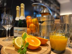 a cutting board with oranges and a glass of orange juice at Hotel Haunstetter Hof Augsburg in Augsburg