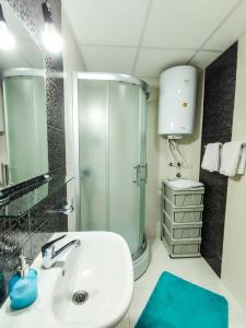 a bathroom with a white sink and a shower at Sleep & Rest in Skopje