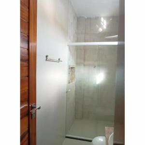 a bathroom with a shower with a glass door at Pousada BarbacoaR in Parnaíba