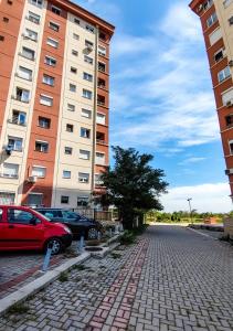 a red car parked next to two tall buildings at Sleep & Rest in Skopje +7 photos