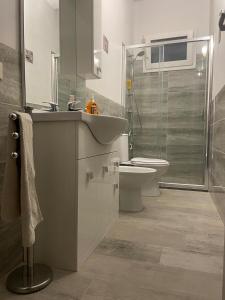Un baño con lavabo, inodoro y ducha. en Casa Malù, en Marina di Noto