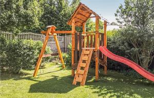 a wooden playground with a slide and a ladder at Beautiful Home In Darlowo With 3 Bedrooms in Darłowo