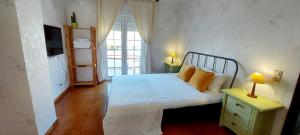 a bedroom with a white bed and a window at Soleil Bleu in Vila Nova de Milfontes