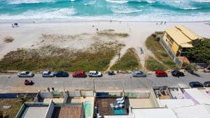 uma vista aérea de uma praia com carros estacionados em Casa do Beiral Azul 5 Qts Pé na areia Piscina em Cabo Frio