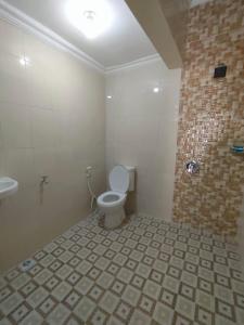 a bathroom with a toilet and a shower at Sierra Homestay Malang 3 BR AC in Ngadipuro +13 photos