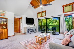 un soggiorno con divano e TV di Waikomo Stream Villas 132 a Koloa