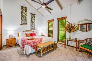 a bedroom with a bed and a table and a chair at Waikomo Stream Villas 132 in Koloa