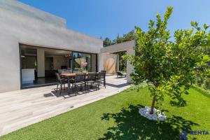 a backyard with a table and chairs and a tree at Cannes Hills Lovely Villa Pool & Garden in Le Cannet