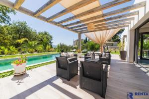 um pátio com cadeiras e uma piscina em Cannes Hills Lovely Villa Pool & Garden em Le Cannet