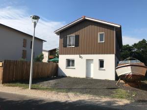 dom z łodzią przed nim w obiekcie Maison 8 personnes Biscarrosse bourg w mieście Biscarrosse