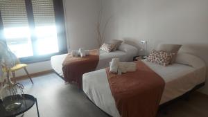 Habitación con 2 camas y sofá. en New J&J Hostel, en Ourense
