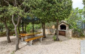 a picnic table and bench in a park at Stunning Apartment In Mandre With Wifi in Mandre