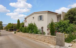 a house on a street with a stone wall at Stunning Apartment In Mandre With Wifi in Mandre