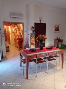 tavolo da pranzo con sedie e vaso di fiori di IL MULINO Appartamento Itri centro 150 m2 con ampio terrazzo completo di tutti i comfort a Itri