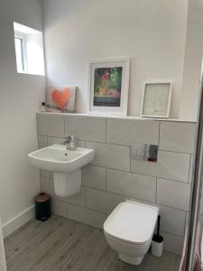 La salle de bains est pourvue de toilettes et d'un lavabo. dans l'établissement Sea Breeze Cottage Swanage Bay, à Swanage