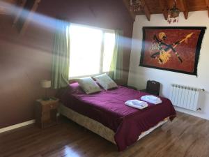 a bedroom with a bed with purple sheets and a window at LA CASONA in Villa General Belgrano +11 photos
