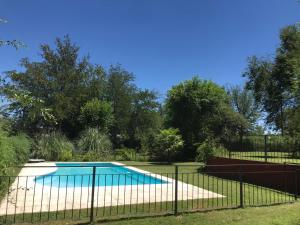 a swimming pool behind a fence at LA CASONA in Villa General Belgrano